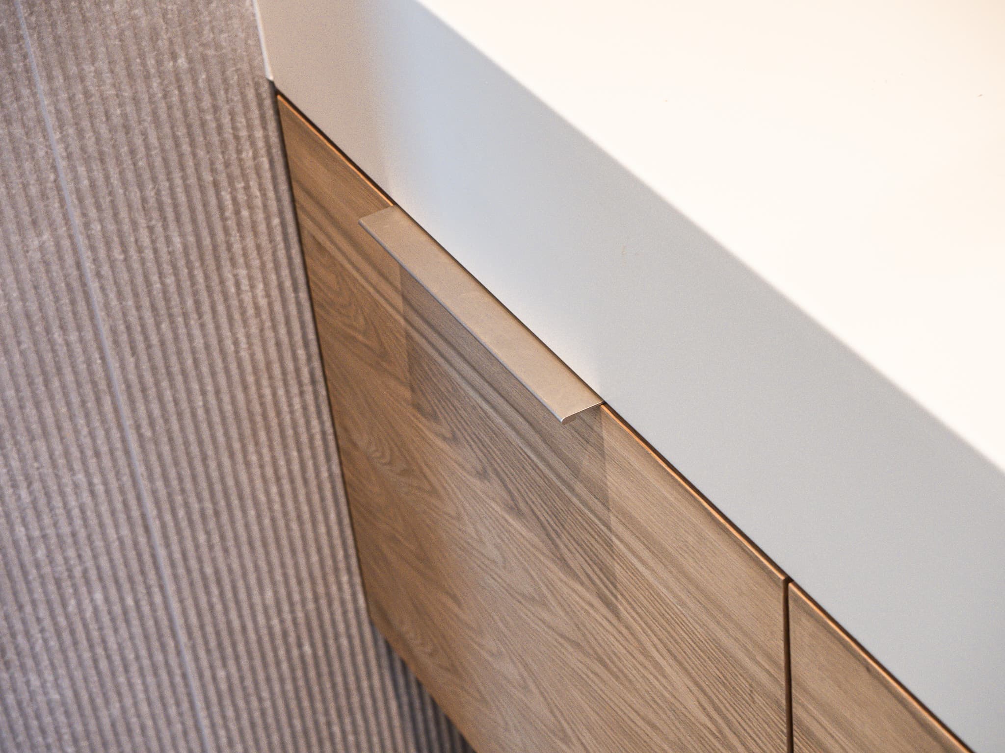 wood vanity corner with white countertop and pull