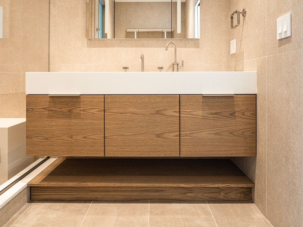 floating three-door vanity with dual deck faucets