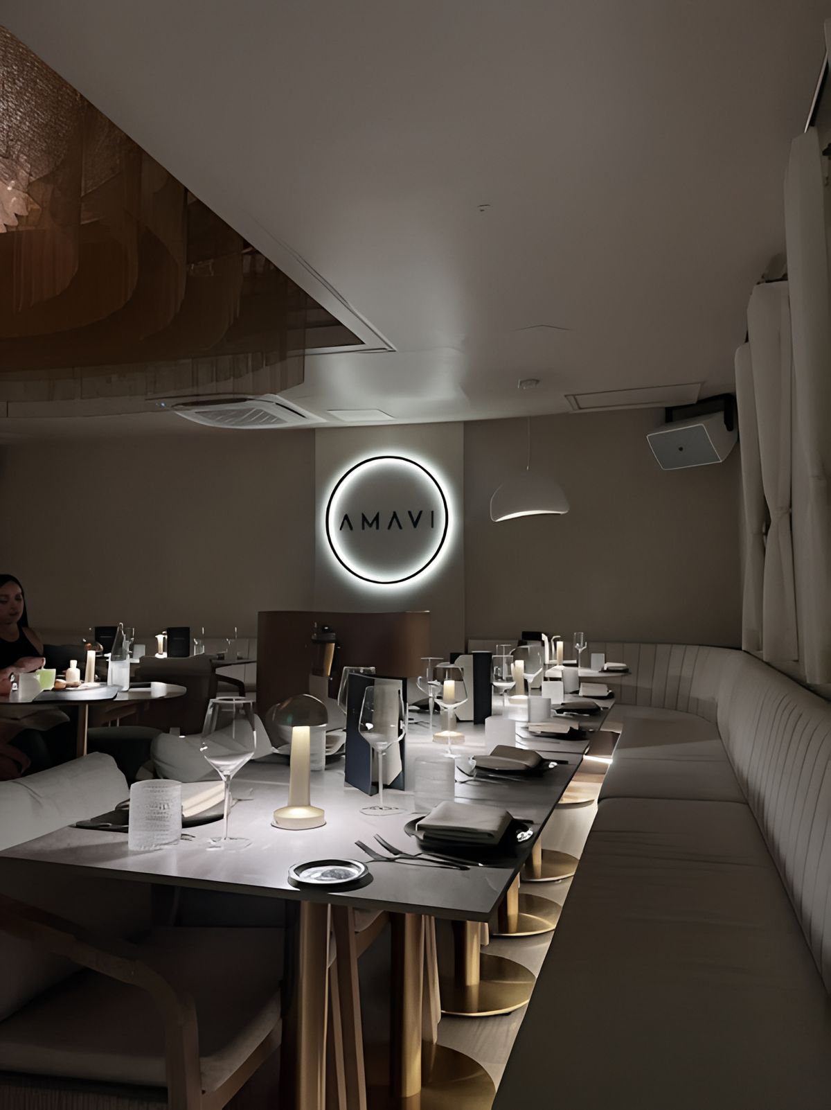 long communal table with illuminated amavi sign