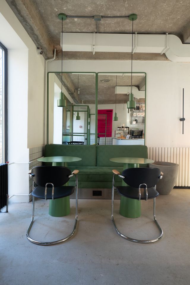 green banquette with mirror backdrop, symmetrical arrangement