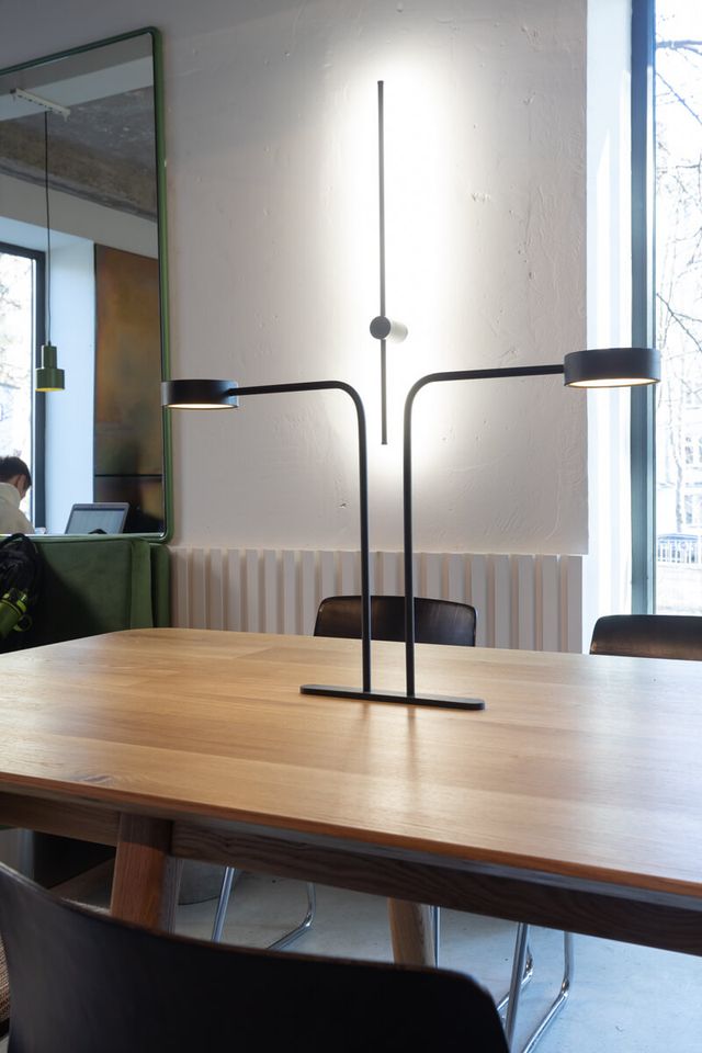 designer twin-arm table lamp detail on communal table