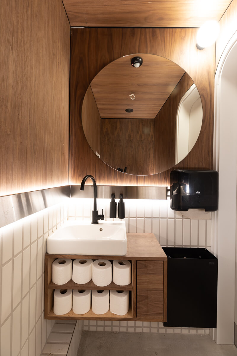 bathroom interior: walnut box with backlit mirror