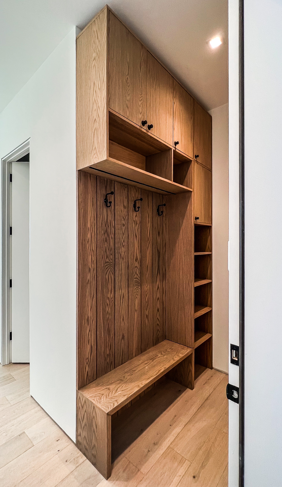 light wood mudroom bench with slat hooks and cubbies