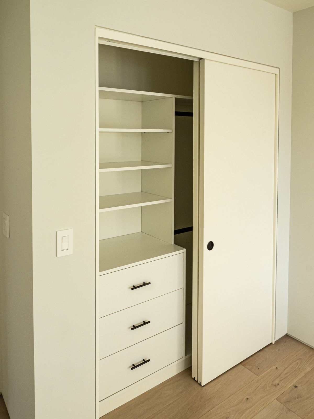 white closet interior with drawers and hanging rod