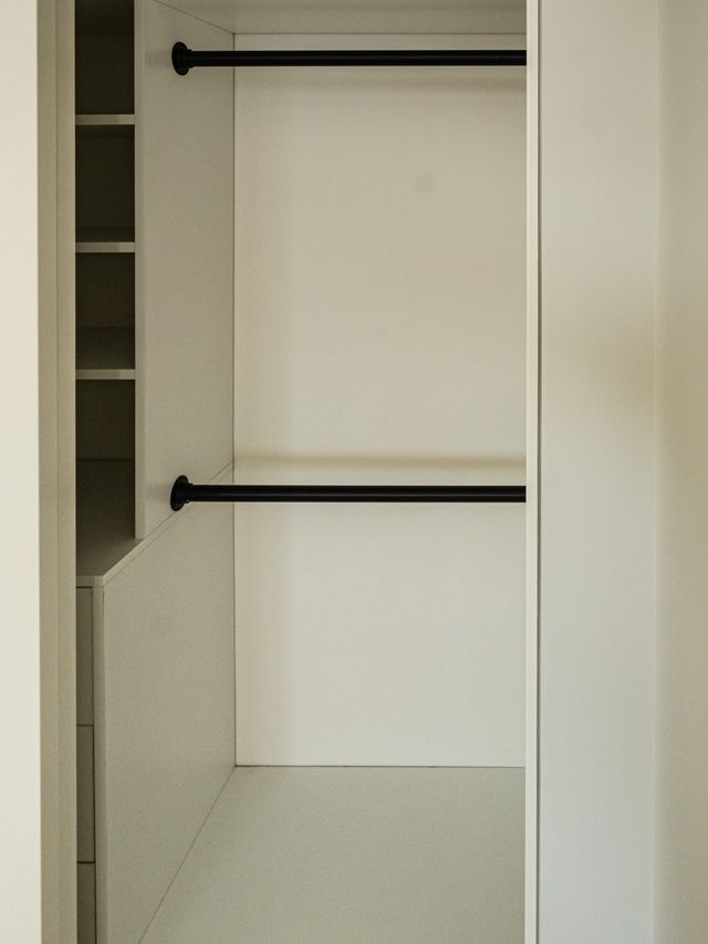 white closet with double black hanging rods