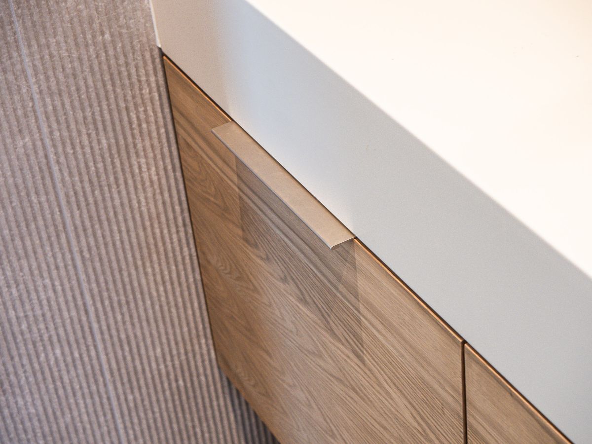 wood vanity corner with white countertop and pull