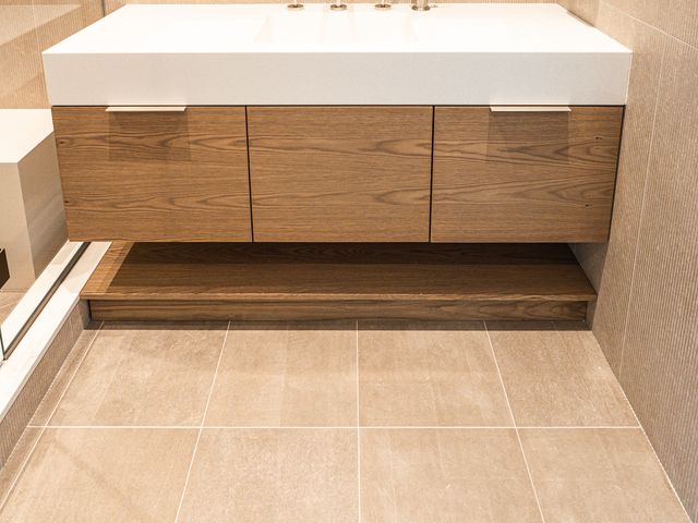 floating wood bathroom vanity with ribbed tile wall
