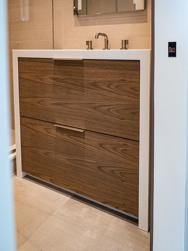 wood-grain vanity with white frame and arched faucet