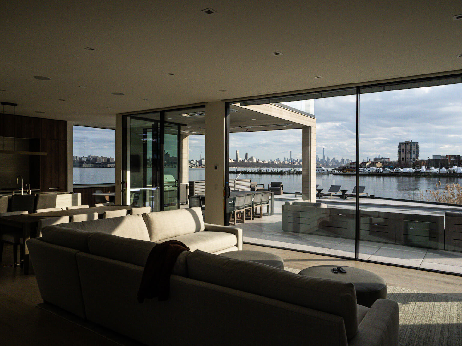 living room opening to waterfront terrace and skyline
