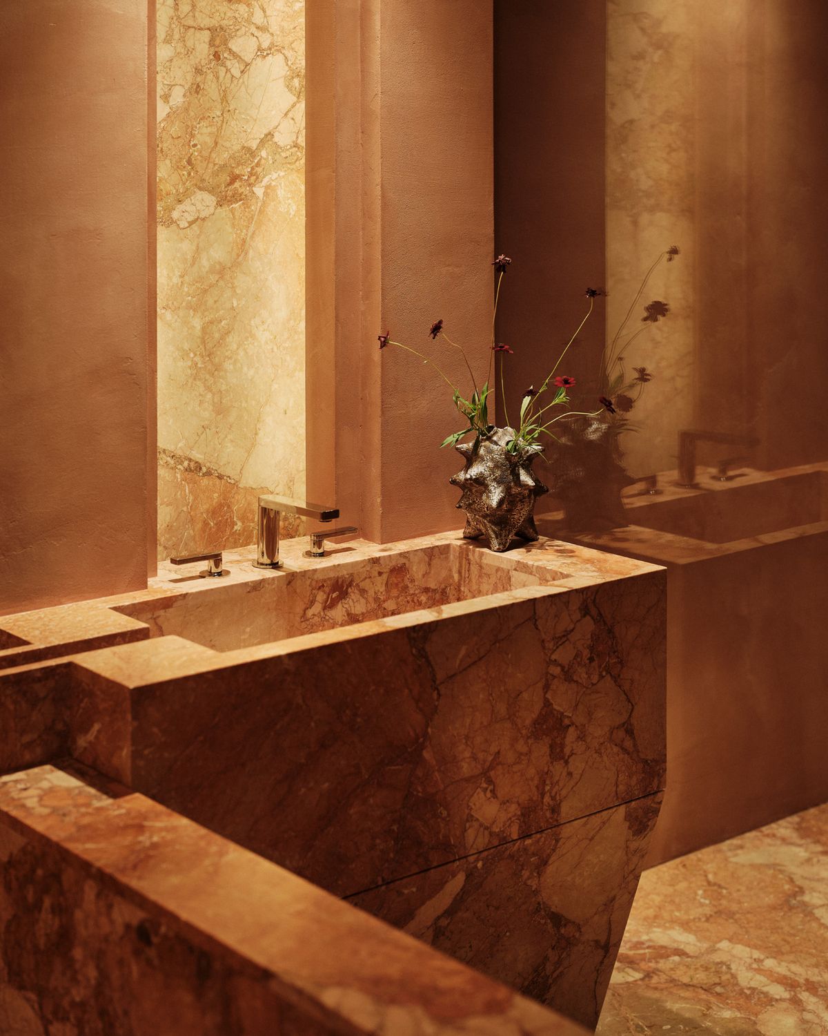 stone vanity with a square basin and a backlit stone panel
