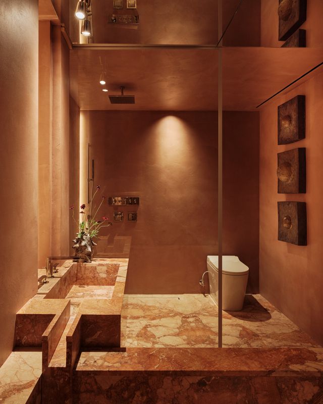 shower room with a stone vanity, glass screen and bronze wall pieces