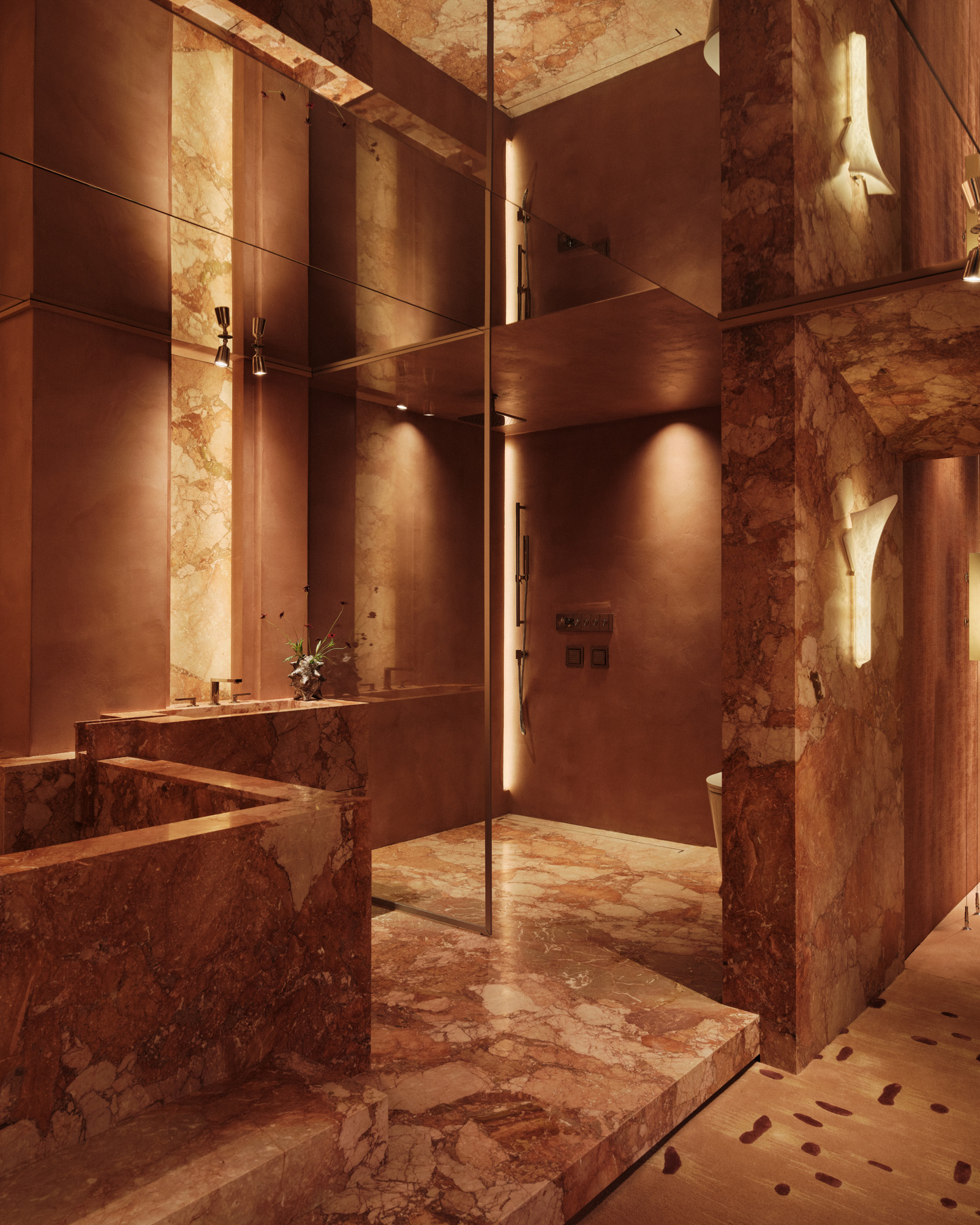 bath with a stone tub, mirrored walls and a glass screen