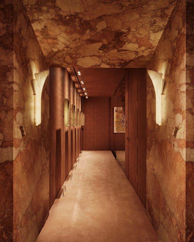 stone-lined hallway with wall sconces and a stone doorway
