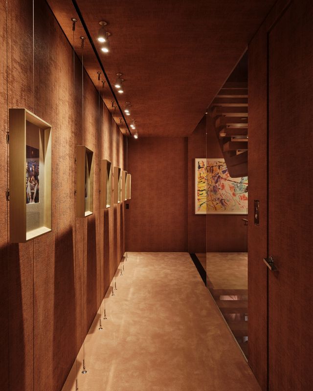 hallway with framed photographs on one side and a stair on the other