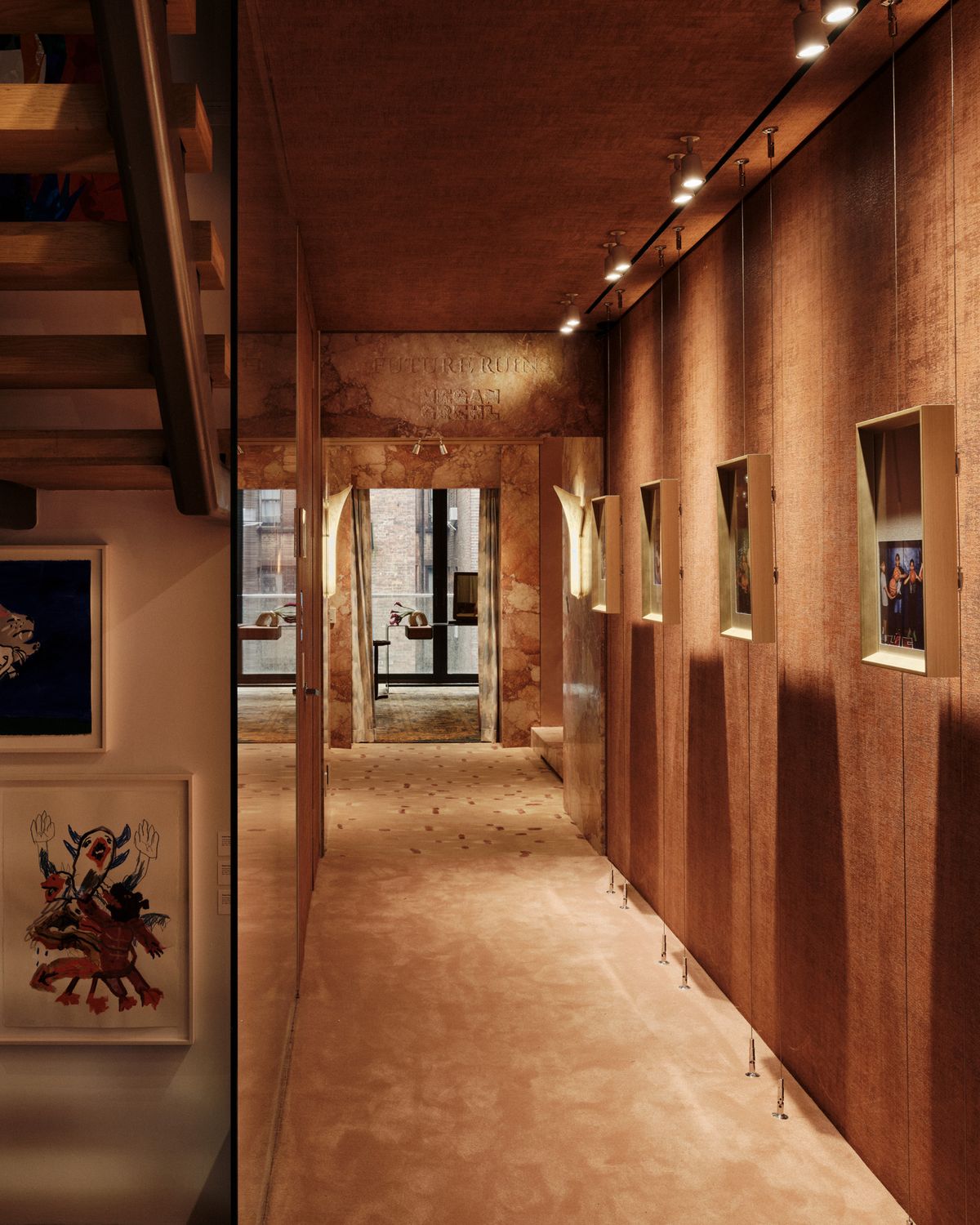 hallway hung with framed photographs leading toward a stone doorway