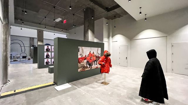 red parka photo on green partition with mannequin