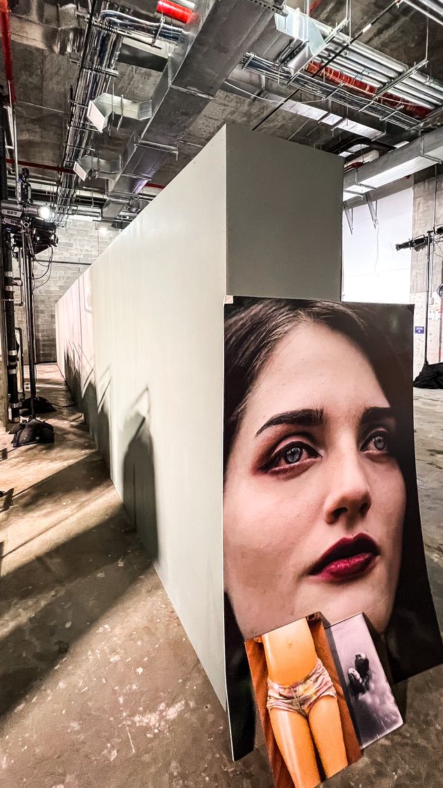 large portrait prints leaning on white partition