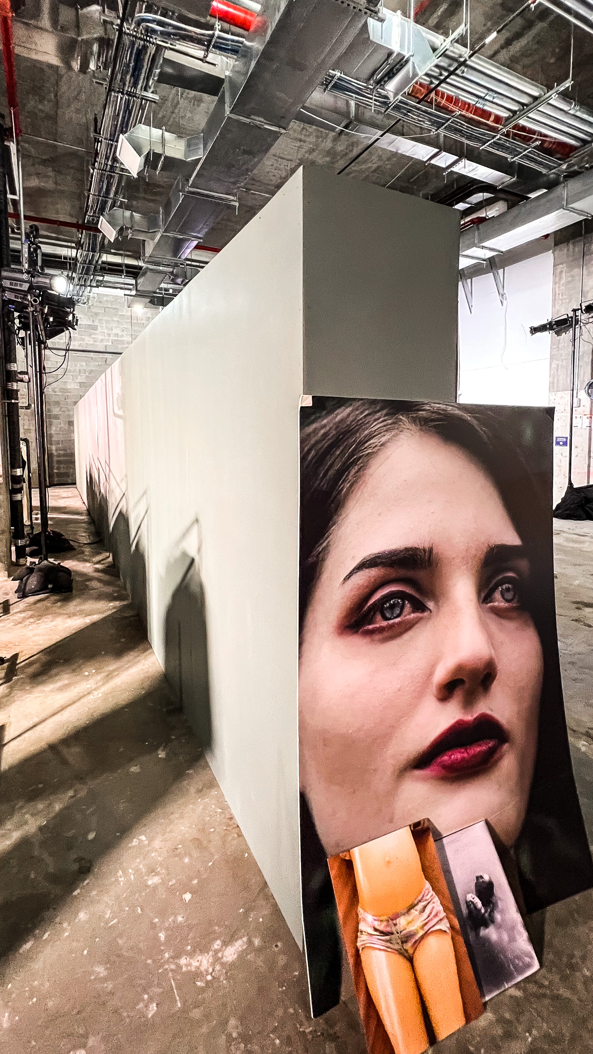 large portrait prints leaning on white partition