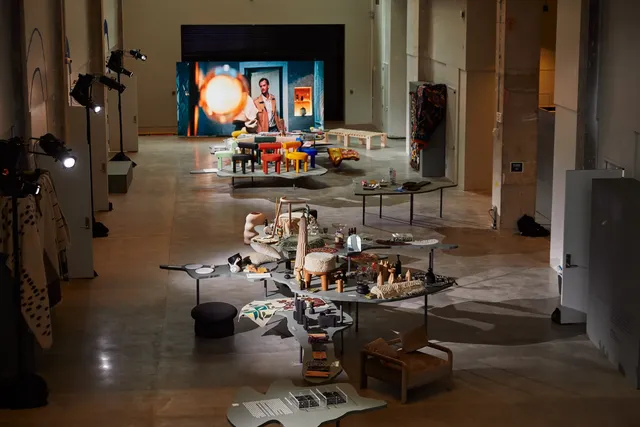 design exhibition with colorful stools on grey tables
