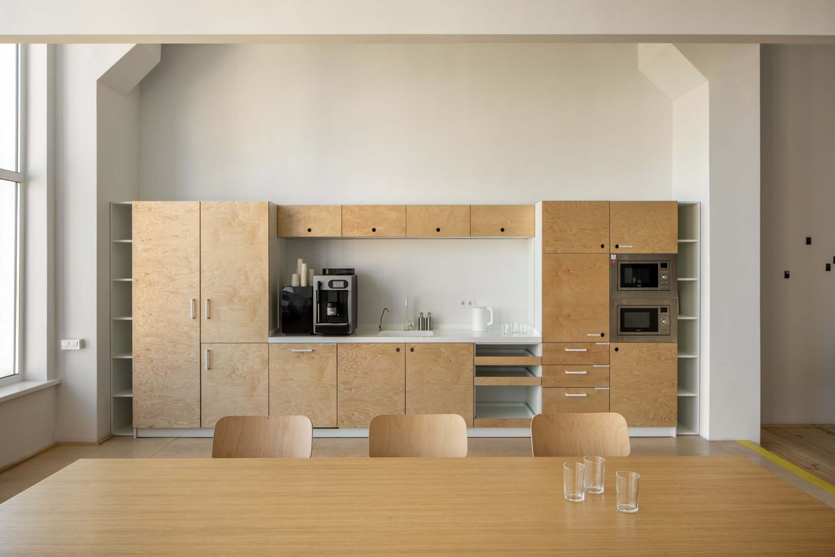 plywood kitchenette with built-in ovens and dining table