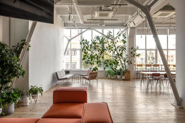 open coworking lounge with communal table and plants