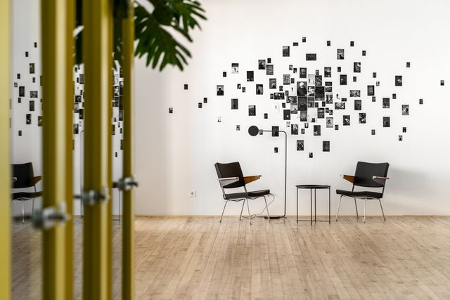 photo collage wall with mid-century black lounge chairs