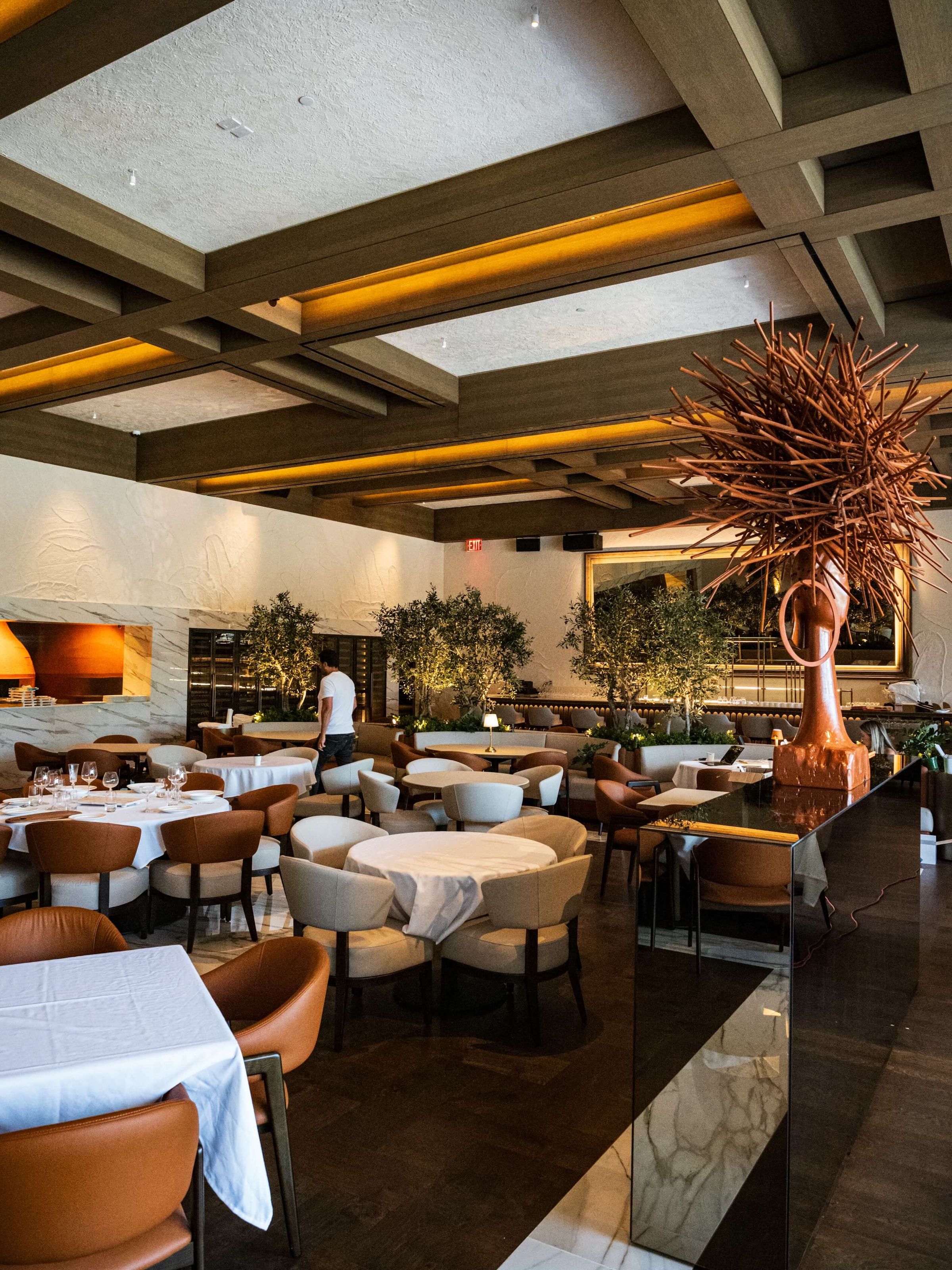 dining hall with copper head sculpture and mirrors