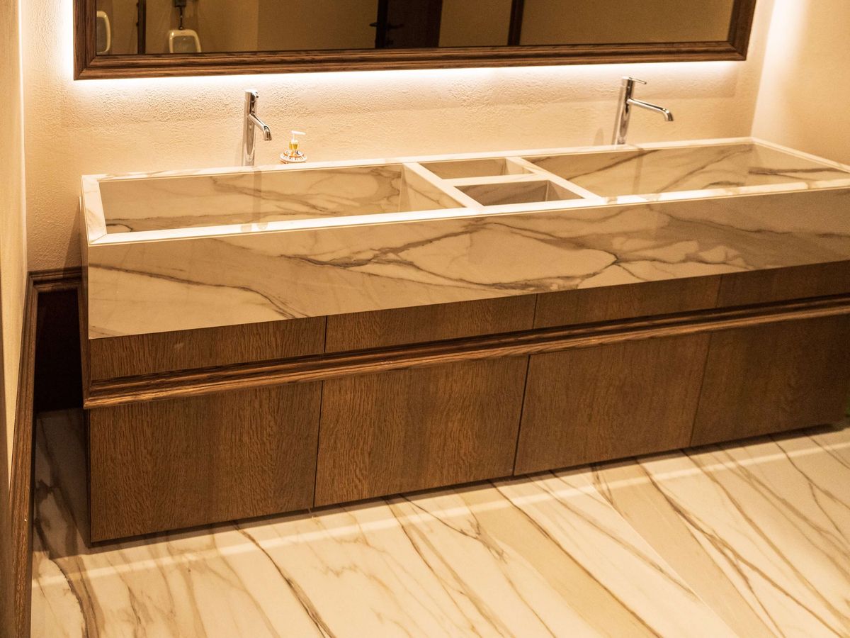 double trough marble vanity with wood cabinets
