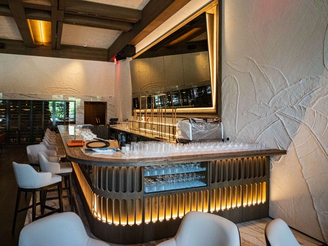 curved bar with palm relief wall and coffered ceiling