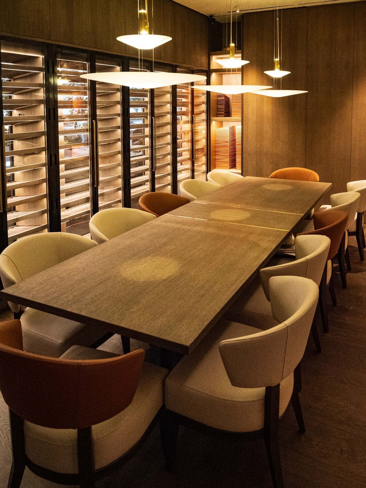 long wood table with disc pendants and wine cellar
