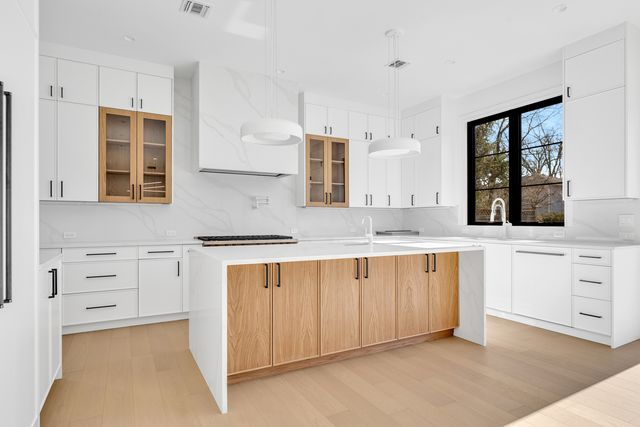 kitchen with waterfall island and range wall