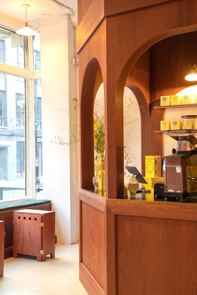 pointed-arch wood coffee kiosk with yellow branding