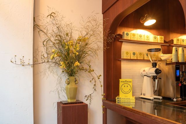 coffee counter with brewer and large floral arrangement
