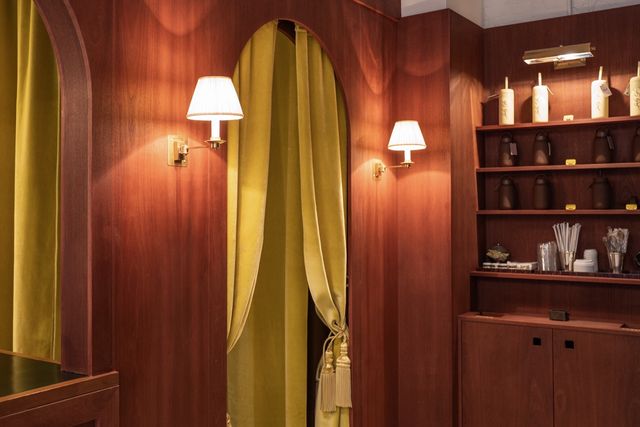 wood interior with curtained arches and brass sconces